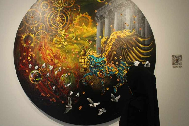 Pengunjung mengamati lukisan yang dipamerkan di Orasis Art Space, jalan bukit golf B2-25, Surabaya (foto: Foto: Athalia Abigail Purwanto | prapanca.id)